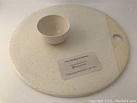 Top view of white speckled ceramic platter with small dish resting on it, featuring a card with Leah Georgina Design contact information.