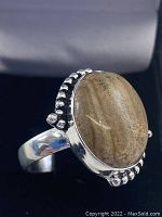 Close-up side angle of the oval Picture Jasper set in sterling silver ring with decorative silver beads on the sides.