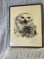Framed black and white stippled print showing an owl and baby, signed by the artist, positioned on a draped fabric background.