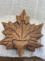 Top view showing the assembled maple leaf puzzle box with detailed carved veins and wood grain.