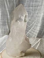 Front view of natural quartz crystal point showing clear pointed termination and internal inclusions.