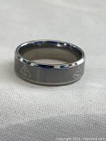 Silver tone Superman ring with multiple engraved 'S' logos visible on band, showing the metallic finish and detail.