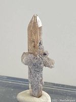 Front view of raw topaz crystal showing transparency, color, and attached matrix