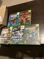 Photo showing all five Xbox games with original cases laid out on a table.