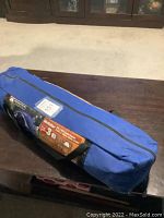 Packed McKellar 7ft x 6ft cabin dome tent inside a blue carry bag with black zipper and handles, tagged with auction lot number.