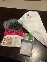 Photo of the full Wilton cake decorating kit showing piping tips, piping bags, and instructional guides spread on a table