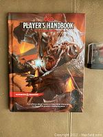 Front cover of the Dungeons and Dragons Player's Handbook hardcover book showing detailed fantasy artwork of a warrior and dragon.