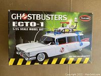 Top view of the Ghostbusters Ecto-1 model kit box showing the finished model image and branding, indicating 1:25 scale and Polar Lights brand.