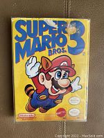 Front view of Super Mario Bros. 3 original NES game box showing Mario in raccoon suit with damage spots on box.
