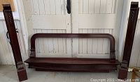 Three separate sections of the fireplace mantel (two pilasters and center shelf/overmantel) laid out on floor