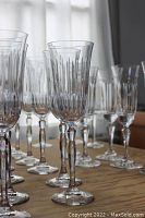 Crystal flute glasses arranged on table showing different vertical cut designs and faceted stems