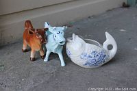 Three vintage ceramic creamers/sauce boats including a white and blue Crown Devon fish, a blue Delft cow, and an unmarked brown cow.