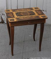 Full view of the vintage Italian inlaid wooden table with music box functionality, showing detailed inlay design and curved legs.