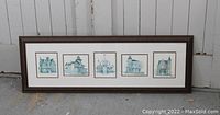 Long horizontal photo of a framed set of five vintage architectural prints depicting buildings in Port Hope, blue-green tone sketches, all aligned in a single dark wooden frame with white matting.