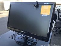 Samsung computer monitor with black bezel and stand shown from the front, power cord attached.