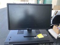 Photo of a Dell computer monitor with black frame and stand, screen off.