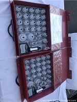 Two red carrying cases containing clear glass cupping cups of varying sizes and a handheld vacuum pump in each case.