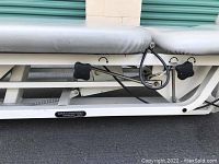 Side view of the medical bed showing manual adjustment knobs and Chattanooga Group Inc branding on the metal frame.