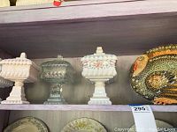 Shelf with three covered candy dishes (two white ceramic, one clear glass) and a ceramic turkey plate