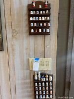 Two wooden shelves mounted on a wall displaying multiple collectible thimbles and two Mickey and Minnie Mouse figurines