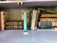 Shelf of assorted cookbooks showing variety and condition.