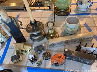 Photo showing assorted elephant figurines, small decorative houses, candleholders, and a wooden figurine.