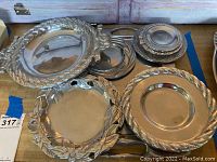 Photo showing the full set of pewter plates and the serving tray with decorative edges and surfaces.