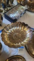 Large silver scalloped edge bowl with reflective surface, showing minor tarnish and scratches. Marking inside bowl reads 'R C D Silverplated 60' indicating brand.