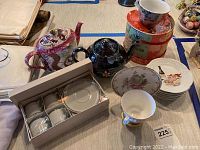 Overview of all items including two tea pots, espresso cup set in box, decorative tea cup with saucer, small appetizer plates and boxed floral cups and saucers