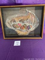 Full view of framed artwork titled "Eggsquisit" by Jane B. Fursh showing the basket with decorated eggs inside and wooden frame.