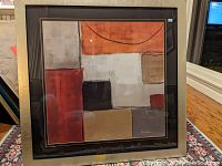 Full frontal image of large abstract print featuring various earth tone color blocks and brushed gold frame