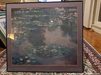 Frontal view of the framed Monet Water Lilies print showing the image of water lilies and reflection on glass.