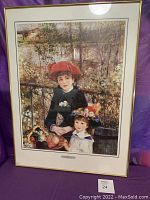 Framed print of Renoir's "On the Terrace" showing two children, one in a red hat, with outdoor scenery behind.