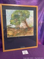 Front view of framed original watercolor and ink artwork titled "Windblown" featuring trees and landscape, encased in light wood frame with black matting.