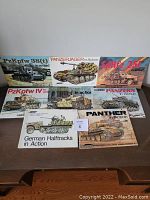 Lot of 8 vintage Squadron/Signal publications on German military vehicles, arranged on a table, showing various tank illustrations and covers.