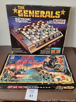 Photo showing boxed games The Generals and Risk The World Conquest Game stacked on a table