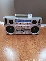 Front view of silver Prosonic boom box with speakers, controls, and cassette player showing missing cassette door and minor wear.