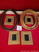 Six vintage frames including two ovals (brown and gold) and four smaller rectangular gold-toned frames.