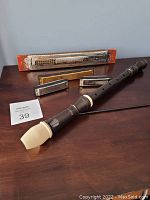 Overall lot showing Aulos 309 flute, Marine Band Echo harmonica, three smaller harmonicas, and Aulos flute case.