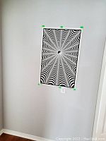 Full view of the black and white velvet backlight poster mounted on a white wall with green painter's tape at the corners.