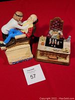 Both figurines placed side by side on red backdrop showing dental office scene and man at desk
