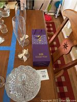 Set displayed on wooden table with blue tape lines for measurement. Includes two champagne flutes, 24K golden rose box, and crystal candy dish with lid.