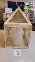 Front view of the pyramid-shaped mesh cover showing material and design, empty inside for candle placement