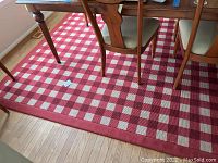 Large red and white checkered carpet under a dining table, showing the overall pattern and size