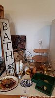 Photo showing wooden 3-tier server, assortment of vases, decorative plates, and hurricane lamp