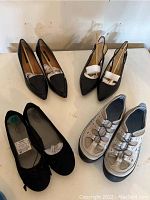 All three pairs of women's shoes on a table showing style and condition