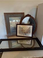 Sailboat print, oval mirror, Paris print framed and leaning on table with long mirror with hooks below