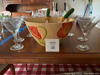 Photo showing wooden salad bowl with floral design surrounded by 8 martini glasses on table