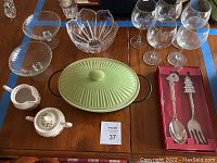 Includes green oval casserole dish with lid, wine glasses, large glass candy dish, floral cream and sugar set.