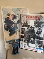 Framed WWII United States Navy recruitment poster featuring sailor and enlistment text with adjacent WWII 50th Anniversary Pacific Victory poster and bobblehead box.